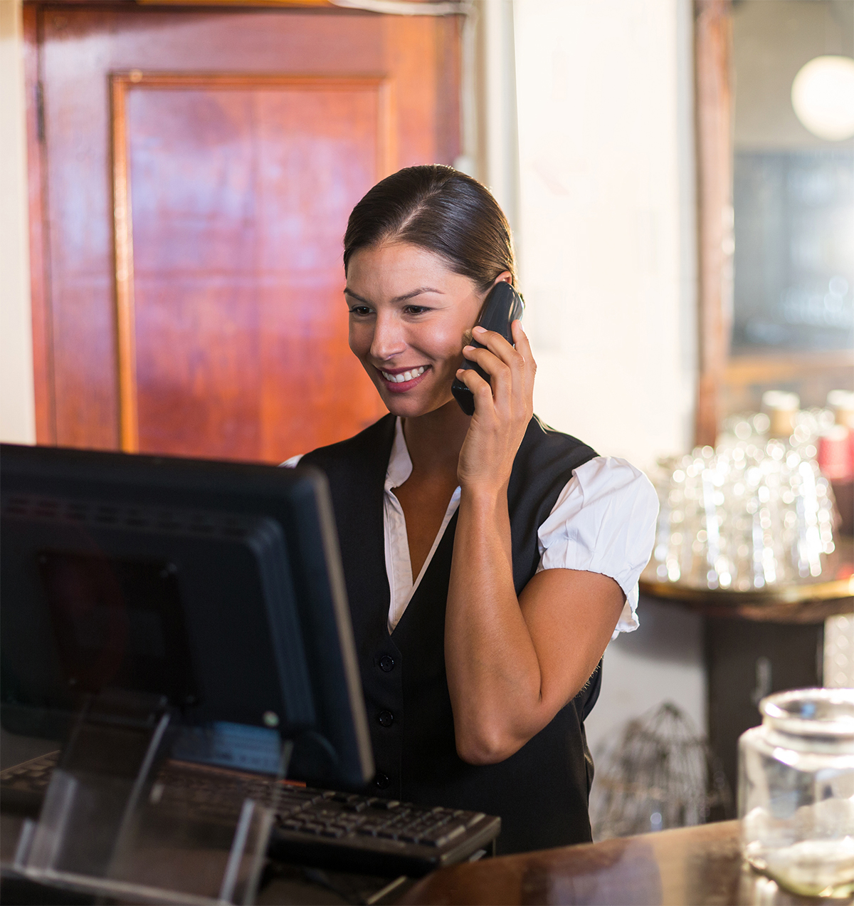 Waitress talking on a phone at counter